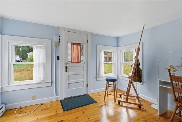 a view of a livingroom with furniture hardwood floor and windows