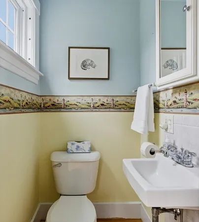 a bathroom with a toilet sink and mirror