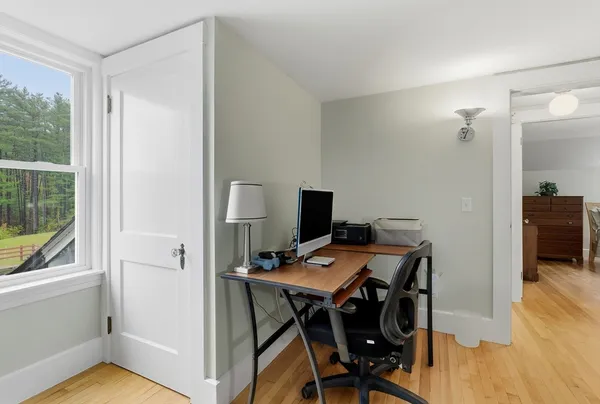 a view of a workspace with furniture and wooden floor