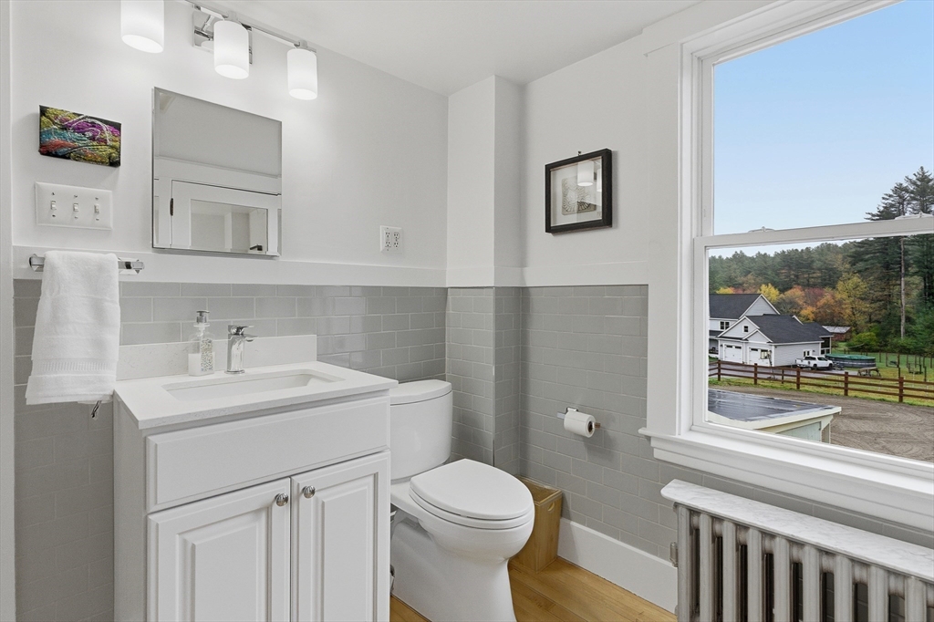 295 Vaughn Hill Road Bolton, MA 01740 - Photo 31 of 38 a bathroom with a sink a toilet and a mirror