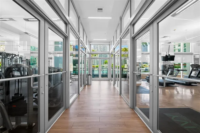 a hallway with hardwood floor and chandelier
