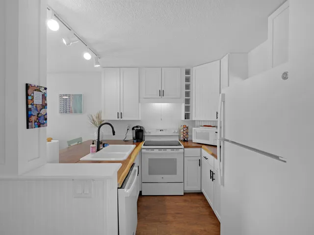 a kitchen with a sink a stove a refrigerator and cabinets