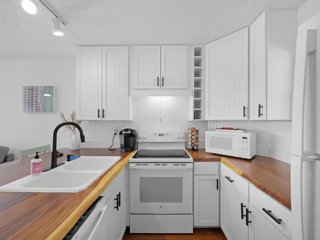 a kitchen with white cabinets and white appliances