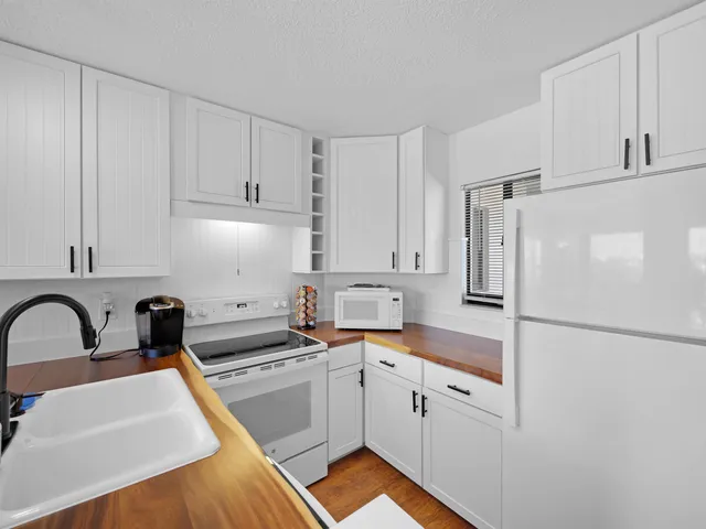 a kitchen with white cabinets and white appliances