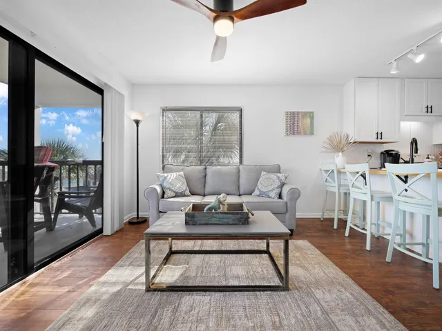 a living room with furniture a wooden floor and next to a window