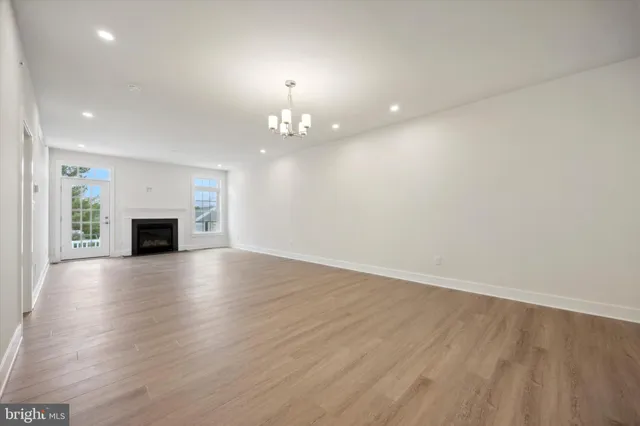 an empty room with wooden floor and fireplace