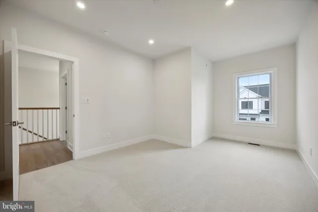 an empty room with windows and chandelier fan