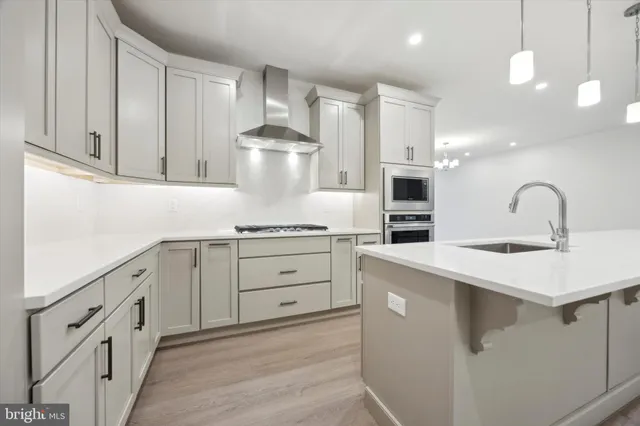 a kitchen with white cabinets appliances and sink