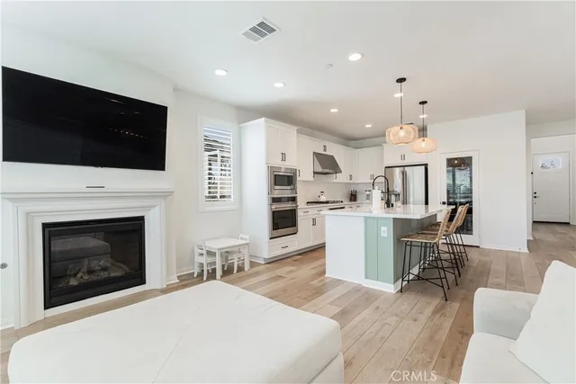 a kitchen with stainless steel appliances a sink cabinets and a wooden floor