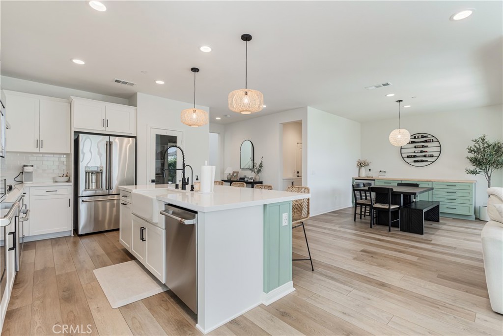32067 Dawning Ridge Temecula, CA 92591 - Photo 10 of 73 a kitchen with stainless steel appliances kitchen island granite countertop a sink cabinets and wooden floor
