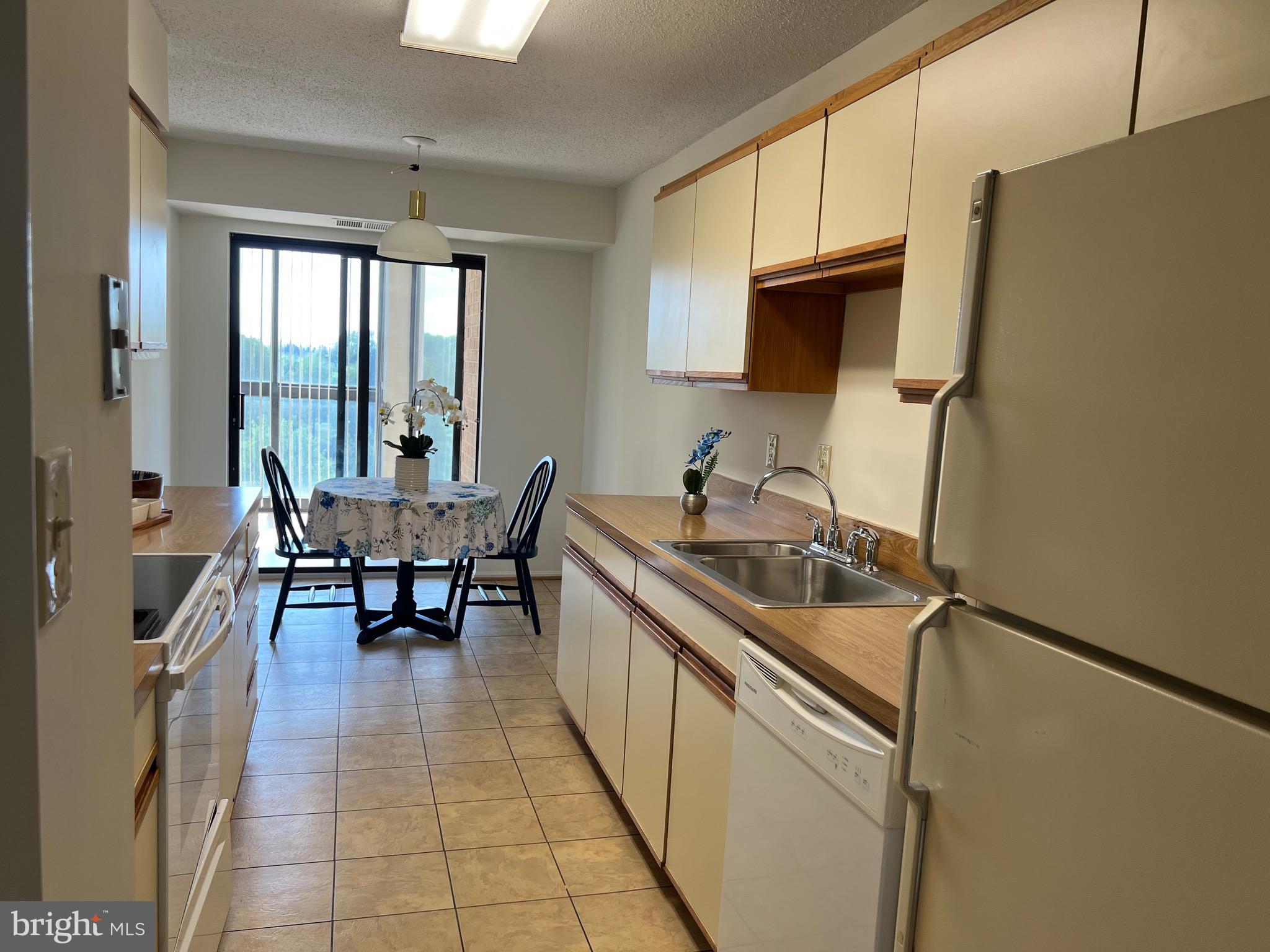 15100 Interlachen Drive, Unit 4709 Silver Spring, MD 20906 - Photo 6 of 22 a kitchen with stainless steel appliances granite countertop sink microwave and refrigerator