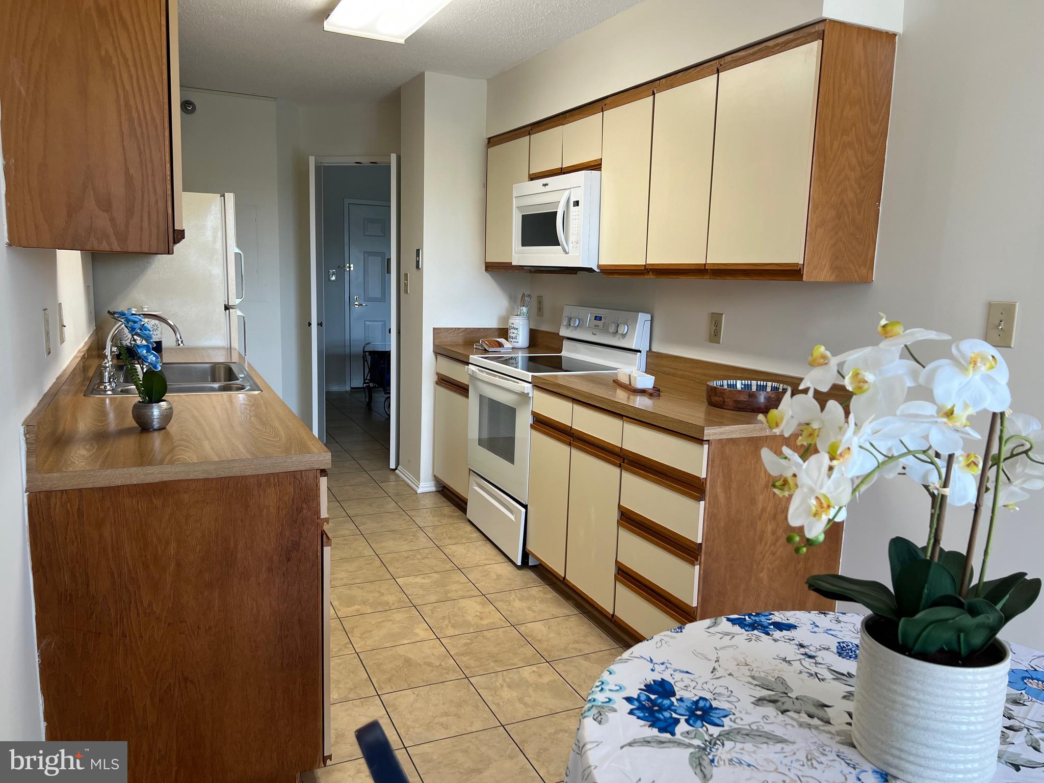 15100 Interlachen Drive, Unit 4709 Silver Spring, MD 20906 - Photo 7 of 22 a kitchen with stainless steel appliances a stove a chimney a sink and cabinets