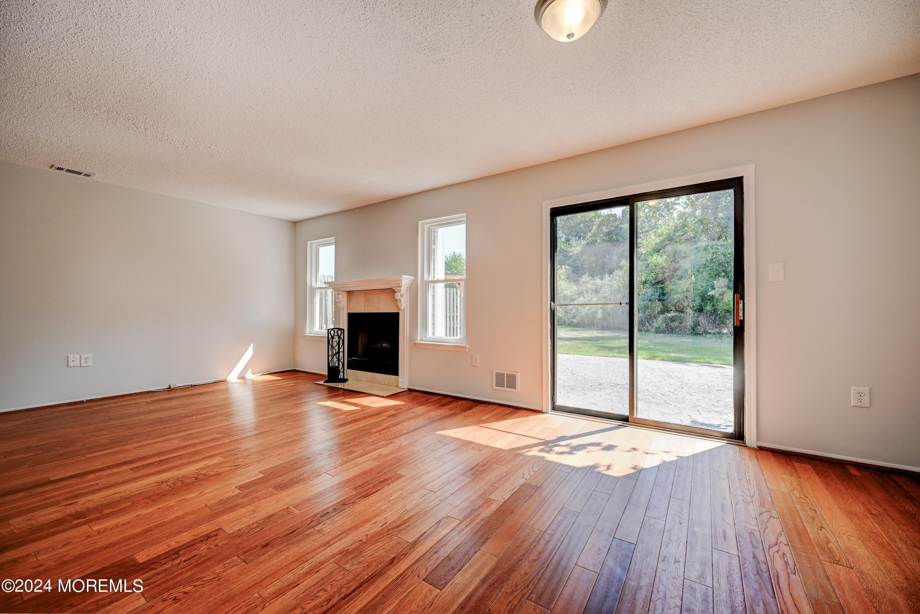 44 Mariners Cove Freehold, NJ 07728 - Photo 11 of 38 a view of empty room with wooden floor and fireplace