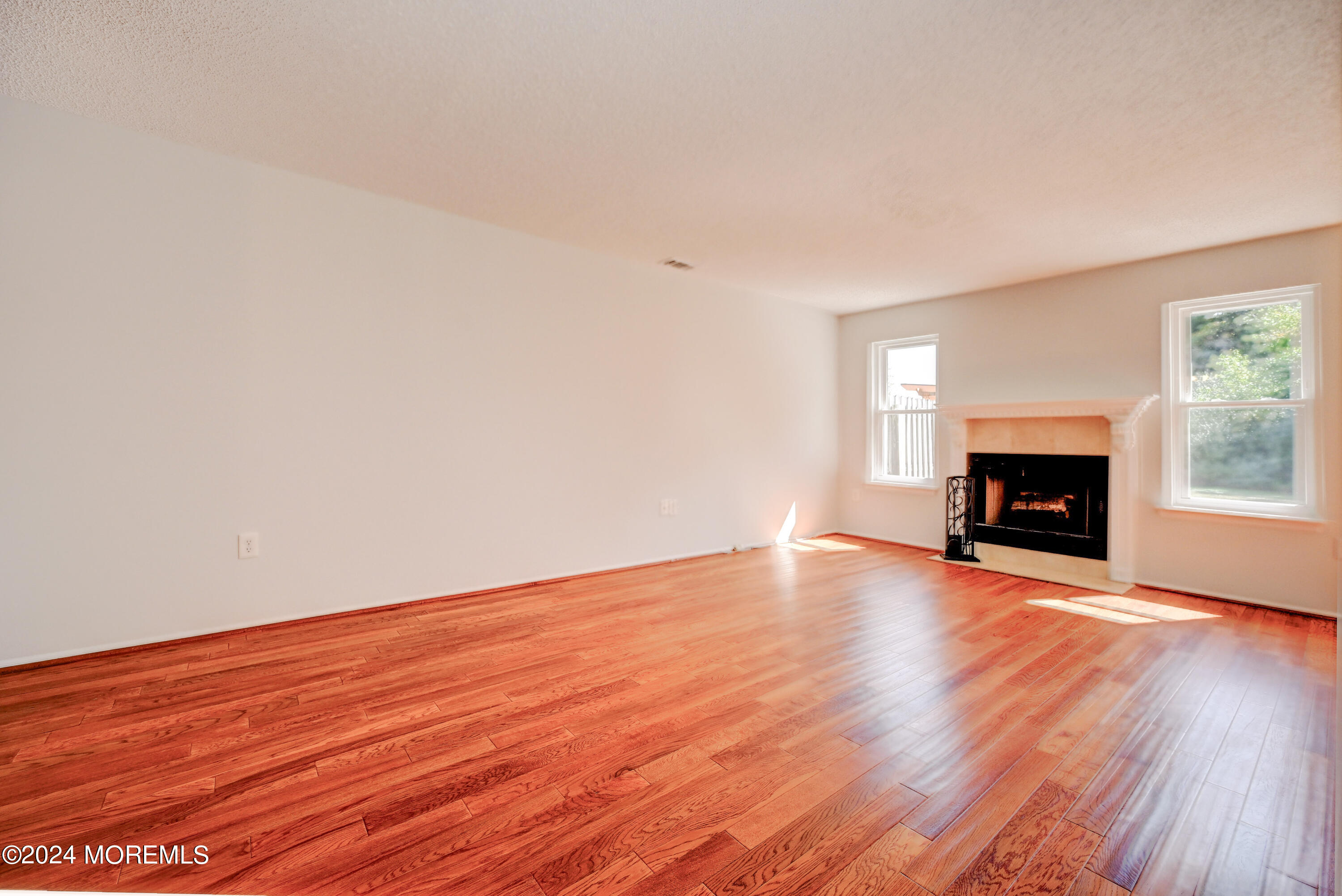 44 Mariners Cove Freehold, NJ 07728 - Photo 15 of 38 a view of empty room with wooden floor and fireplace