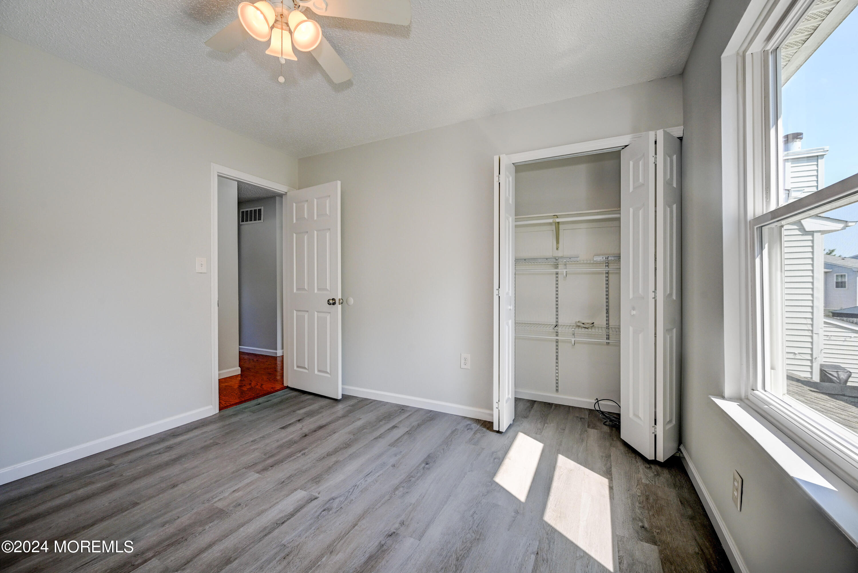 44 Mariners Cove Freehold, NJ 07728 - Photo 21 of 38 a view of empty room with wooden floor and fan