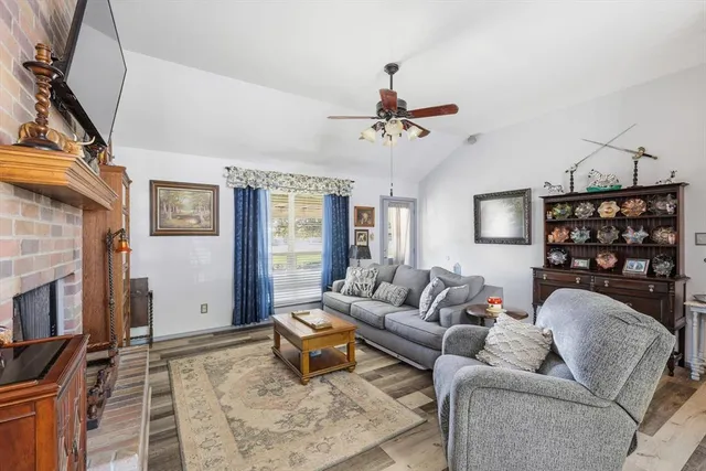 a living room with furniture a fireplace and a flat screen tv