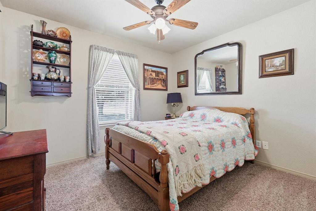 11649 Mitchell Circle Ponder, TX 76259 - Photo 20 of 38 a bedroom with a bed a window and a chandelier