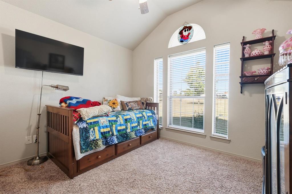 11649 Mitchell Circle Ponder, TX 76259 - Photo 22 of 38 a bedroom with a bed a flat screen tv and a window