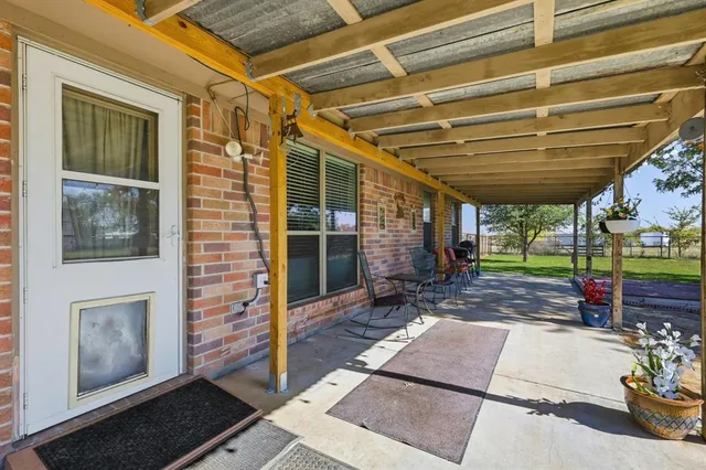a view of a patio with table and chairs with wooden floor and fence