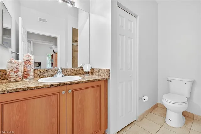 a bathroom with a granite countertop sink toilet and a mirror