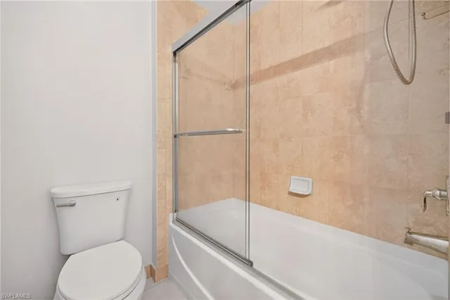 a bathroom with a granite countertop bathtub shower sink vanity and toilet