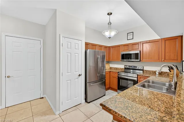 a kitchen with stainless steel appliances granite countertop a refrigerator a stove top oven a sink and dishwasher