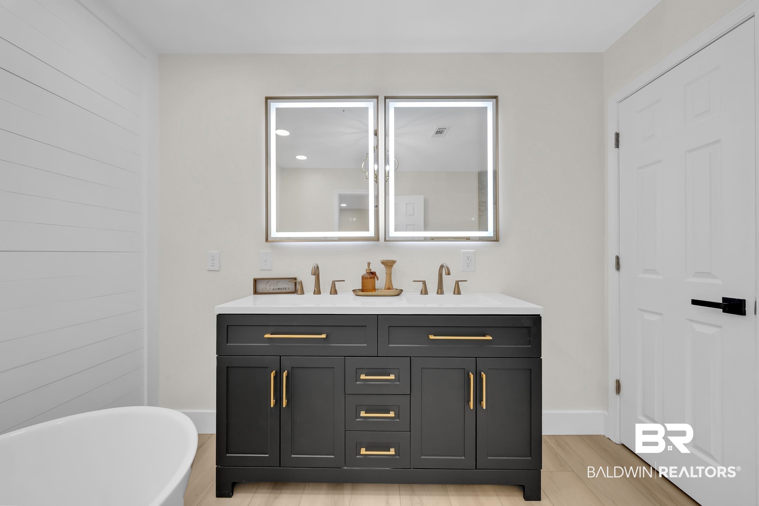 8170 Wilmer Georgetown Road Wilmer, AL 36587 - Photo 14 of 31 Dual vanity with dark cabinetry, white countertop, and gold-finish hardware