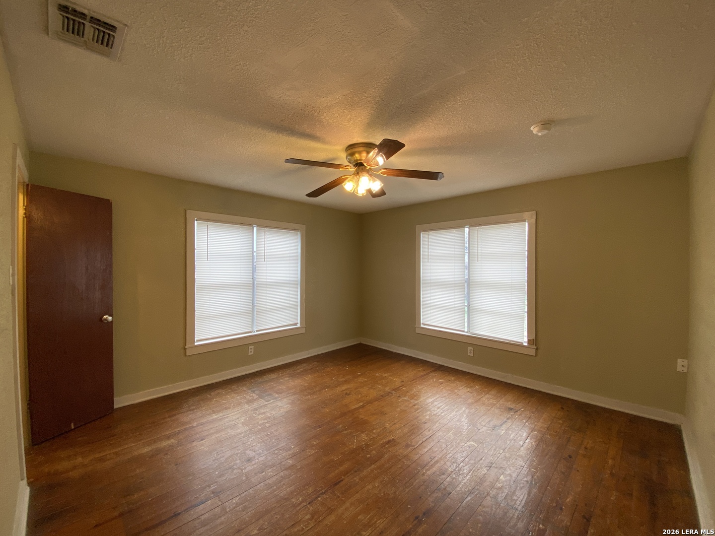 116 Tagert Street Pleasanton, TX 78064 - Photo 4 of 6 a view of an empty room with wooden floor and a window
