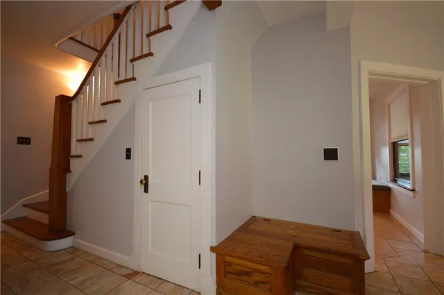 a view of hallway with stairs and wooden floor