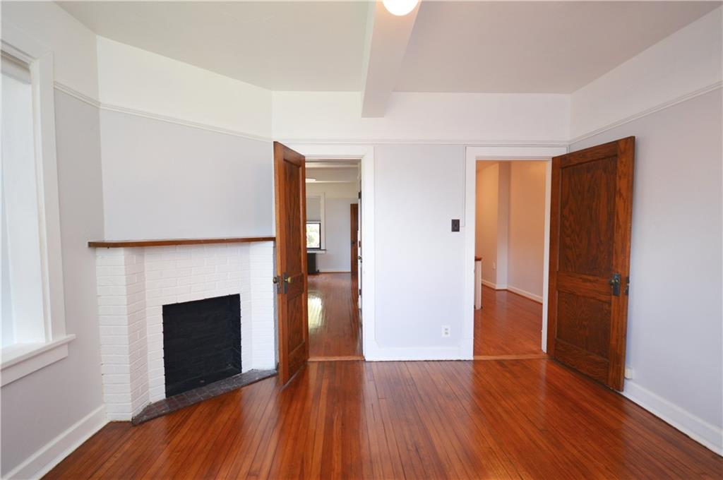 4323 Andover Terrace Pittsburgh, PA 15213 - Photo 33 of 48 an empty room with wooden floor and fireplace