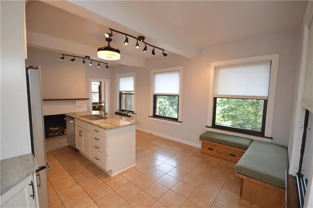 a large kitchen with stainless steel appliances granite countertop a stove a sink and a refrigerator