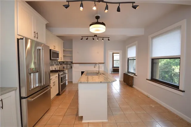 a large kitchen with a large counter top appliances and cabinets