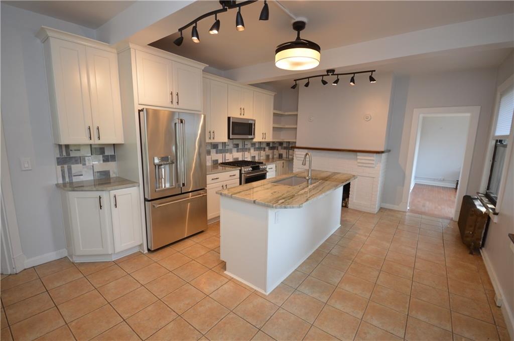 4323 Andover Terrace Pittsburgh, PA 15213 - Photo 9 of 48 a kitchen with kitchen island a counter top a stove a refrigerator and a sink