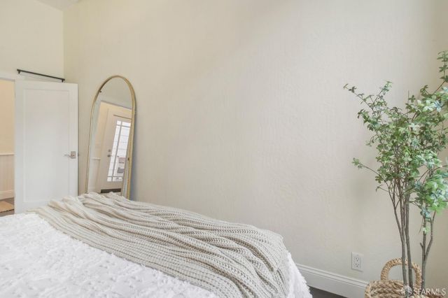 a bedroom with a bed and a potted plant