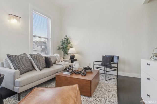 a living room with furniture wooden floor and a window