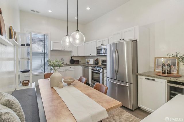 a kitchen with stainless steel appliances kitchen island granite countertop a refrigerator a oven a sink and a refrigerator