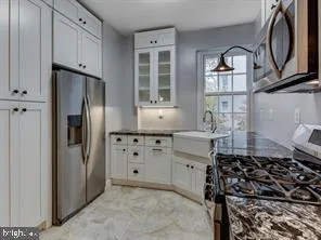 a kitchen with stainless steel appliances granite countertop a refrigerator and a sink