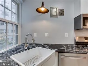 a bathroom with a granite countertop sink and a mirror