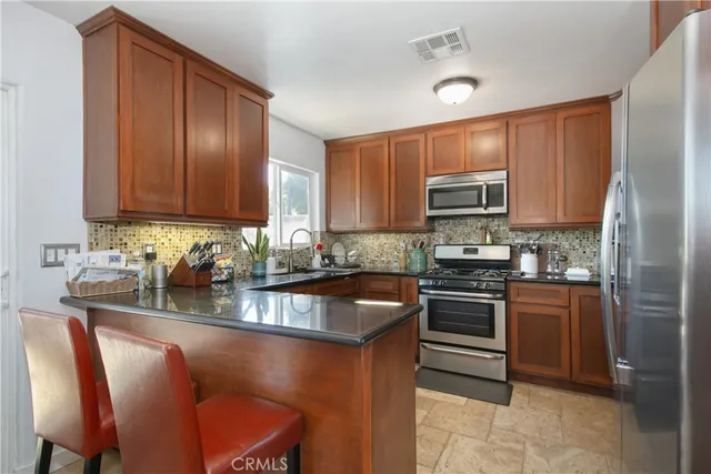 a kitchen with stainless steel appliances granite countertop a stove top oven a sink and dishwasher