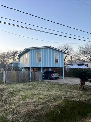 a view of an empty room with window and chandelier fan