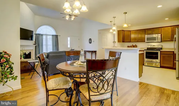 a view of a dining room with furniture a kitchen and chandelier