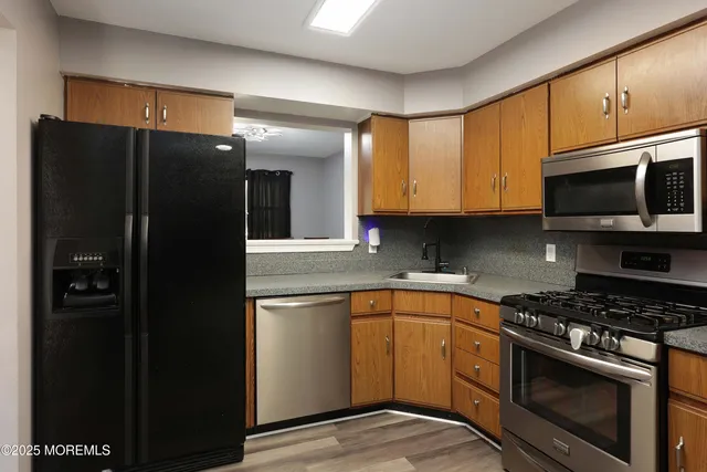 a kitchen with stainless steel appliances granite countertop a refrigerator and a stove top oven