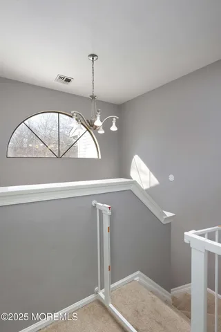 a view of a hallway with a chandelier fan
