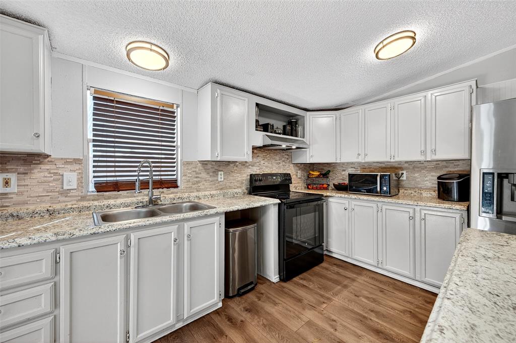 1918 East Foster Crossing Road Anna, TX 75409 - Photo 16 of 27 a kitchen with granite countertop a sink stainless steel appliances and cabinets