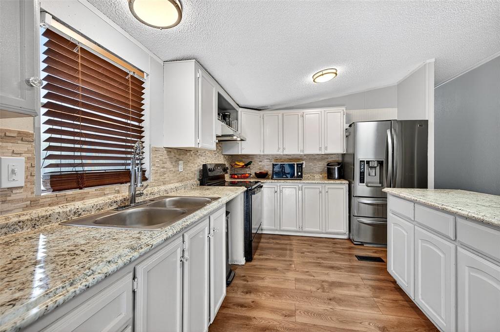 1918 East Foster Crossing Road Anna, TX 75409 - Photo 17 of 27 a kitchen with granite countertop kitchen island a sink stainless steel appliances and cabinets