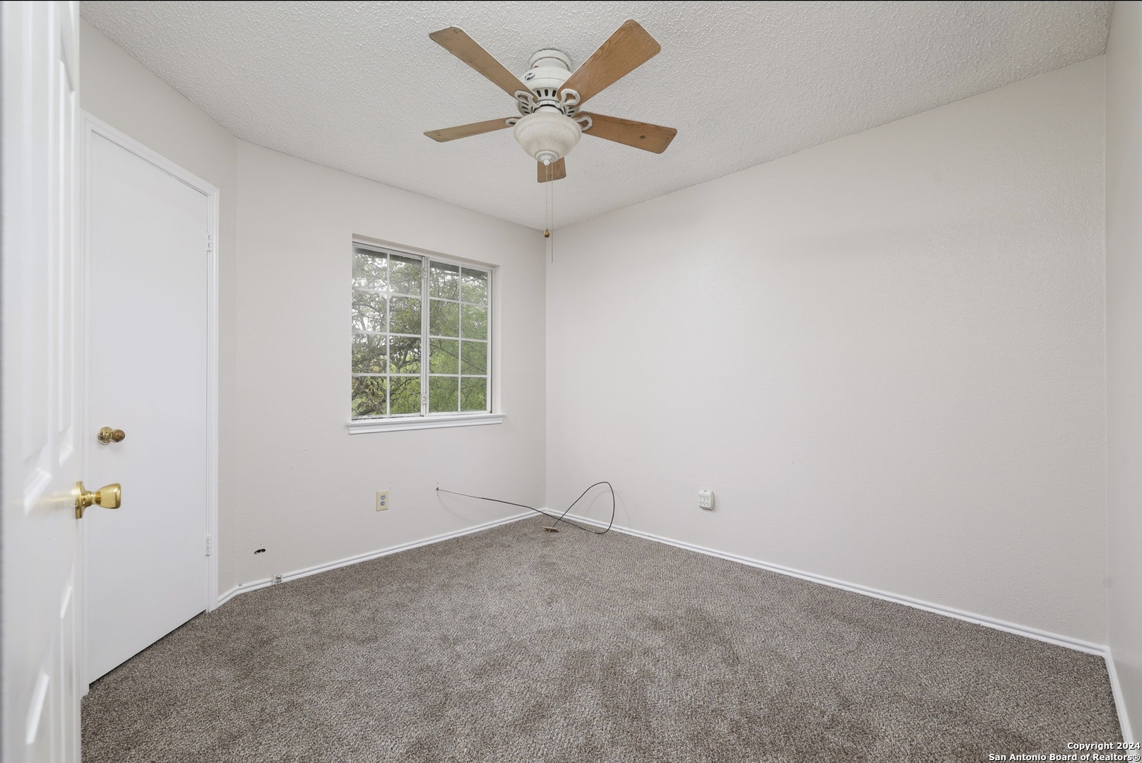 9159 Ridge Mill San Antonio, TX 78250 - Photo 12 of 17 an empty room with a window and a fan