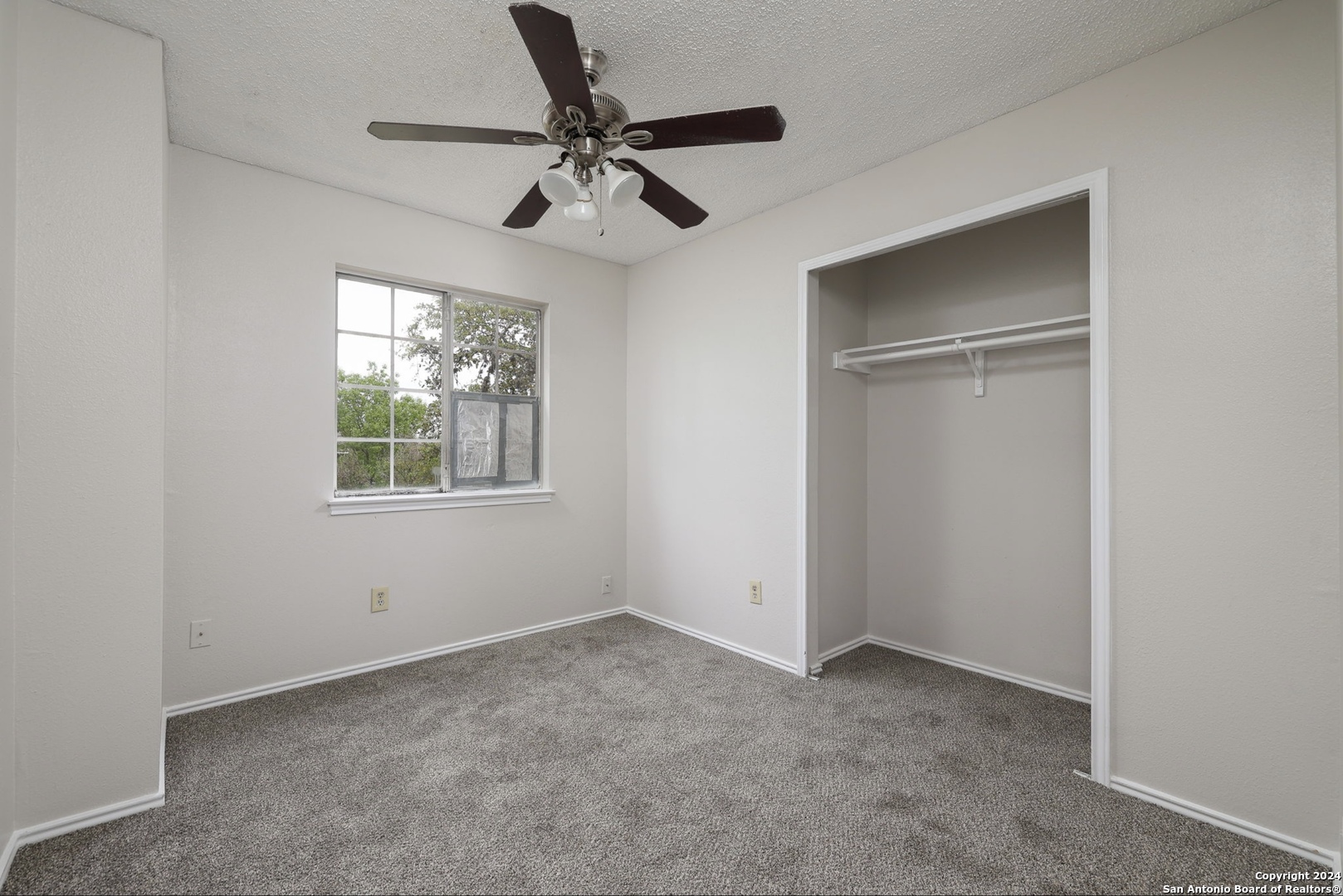 9159 Ridge Mill San Antonio, TX 78250 - Photo 13 of 17 an empty room with windows and fan