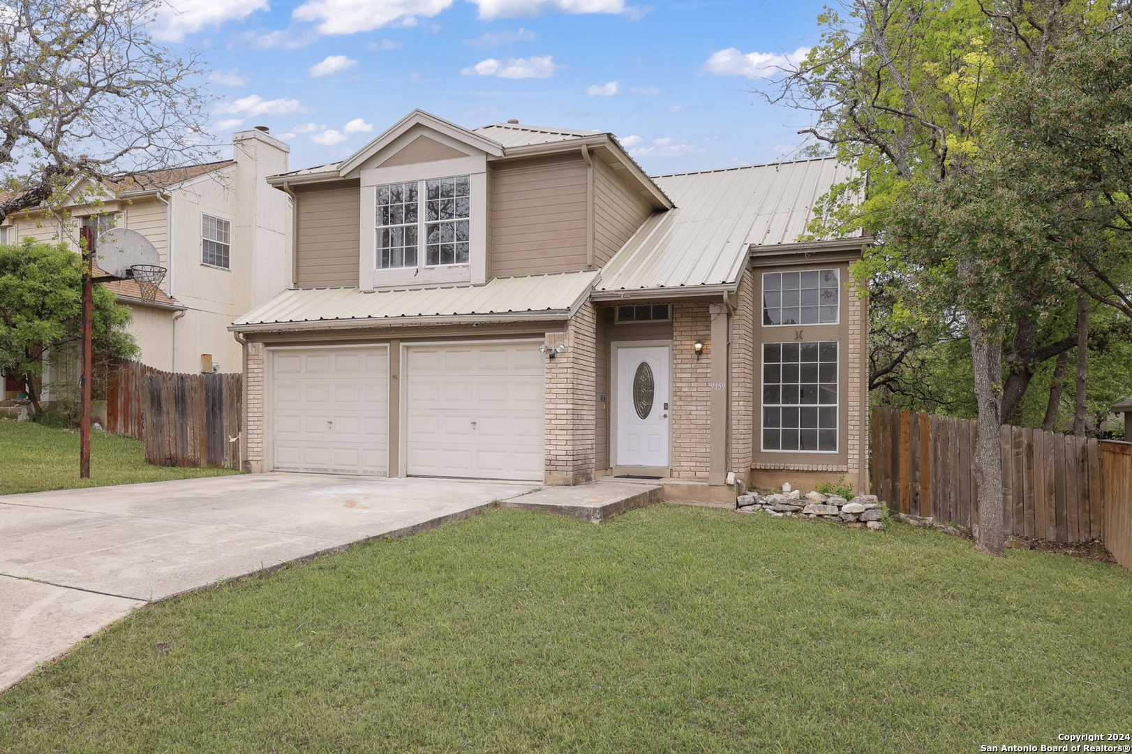 9159 Ridge Mill San Antonio, TX 78250 - Photo 2 of 17 a front view of a house with a garden and yard