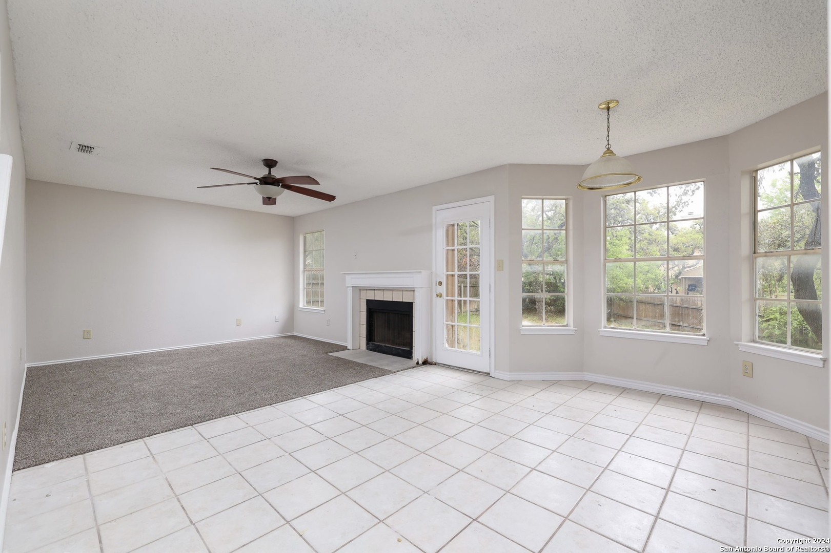 9159 Ridge Mill San Antonio, TX 78250 - Photo 5 of 17 an empty room with windows and fireplace