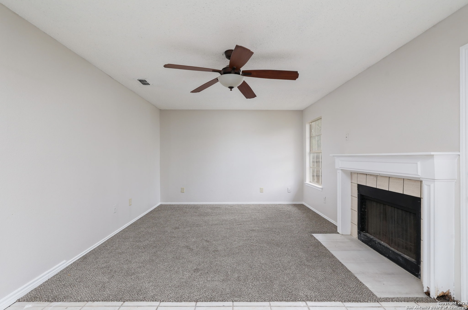 9159 Ridge Mill San Antonio, TX 78250 - Photo 6 of 17 a view of a livingroom with a fireplace and a ceiling fan